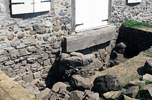 Fouille de la sous-opération 1H. À gauche de la porte, un perron circulaire a été dégagé. Il témoigne, par l'usure de sa surface, de passages répétés de personnes pendant presque tout le dix-huitième siècle.